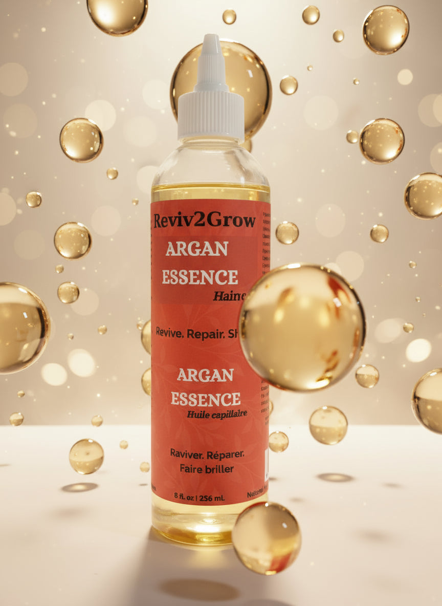 Reviv2Grow Argan Essence hair oil bottle on a white surface with a gray background