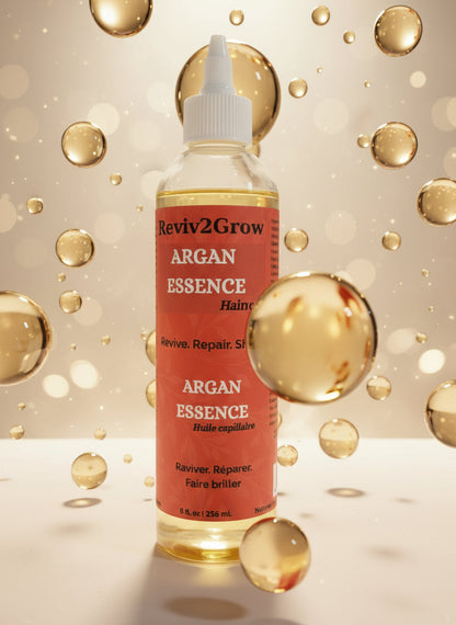 Reviv2Grow Argan Essence hair oil bottle on a white surface with a gray background