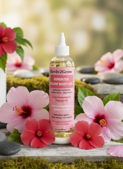 Reviv2Grow Hibiscus Glow Body Oil bottle with flowers and stones in the background