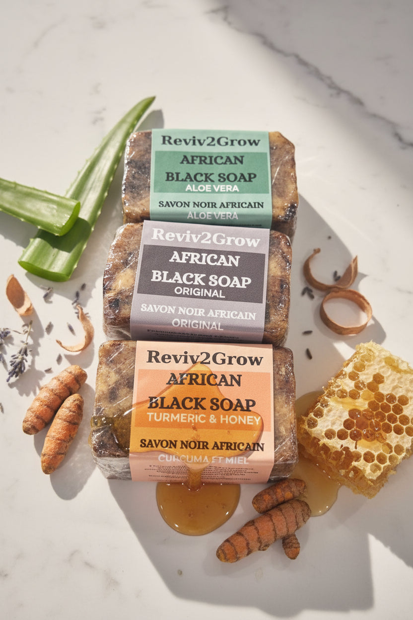 Three bars of African Black Soap from Reviv2Glow on a marble surface.