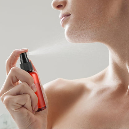 Person holding a red spray bottle near their neck against a neutral background