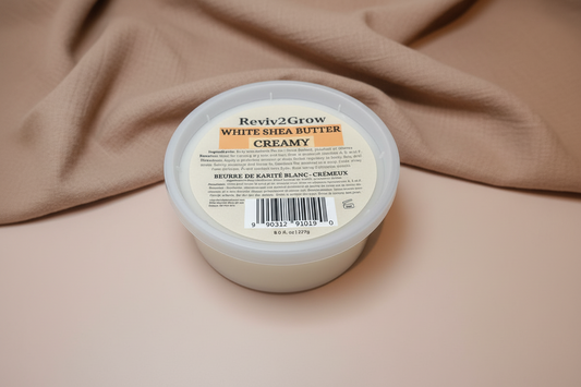 Reviv2Grow White Shea Butter Creamy container on a beige fabric background