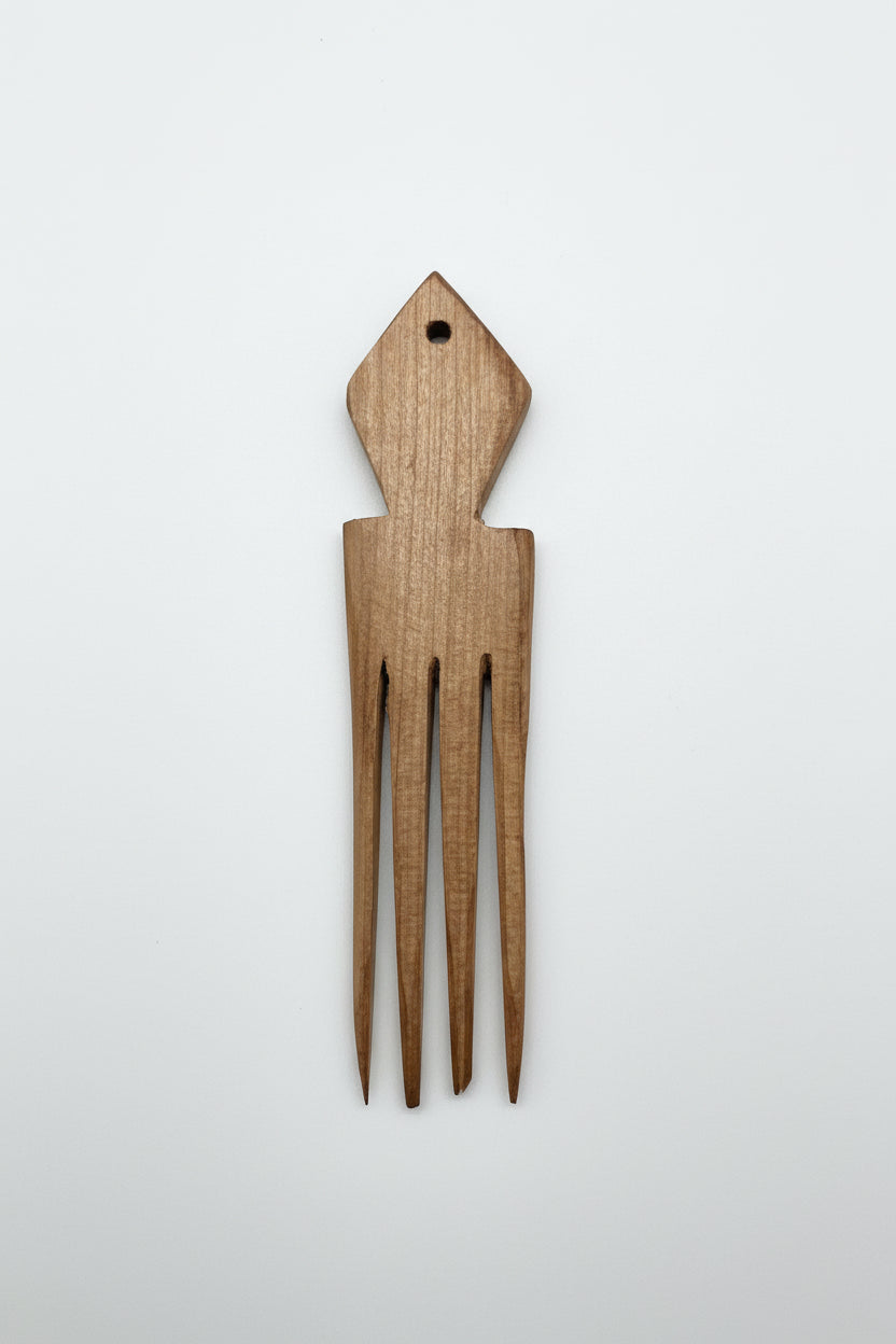 Wooden comb shaped like a fish on a marble surface