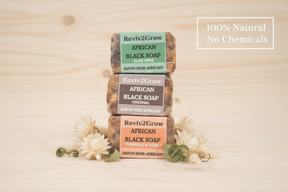 Three bars of African Black Soap from Reviv2Grow on a marble surface.