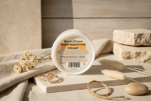 Reviv2Grow White Shea Butter Creamy container on a wooden surface with natural elements.
